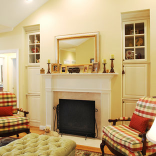 Ispirazione per un piccolo soggiorno classico aperto con pareti gialle, parquet chiaro e camino classico