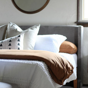 Primary Bedroom with Round Brass Mirror and Copper Bedding