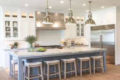 Open concept kitchen - large contemporary l-shaped medium tone wood floor and brown floor open concept kitchen idea in Phoenix with a farmhouse sink, shaker cabinets, white cabinets, marble countertops, white backsplash, subway tile backsplash, stainless steel appliances, an island and gray countertops