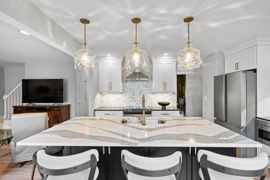 ニューヨークにある高級な中くらいなトランジショナルスタイルのおしゃれなキッチン (アンダーカウンターシンク、シェーカースタイル扉のキャビネット、白いキャビネット、クオーツストーンカウンター、白いキッチンパネル、ガラスタイルのキッチンパネル、シルバーの調理設備、クッションフロア、茶色い床、白いキッチンカウンター) の写真