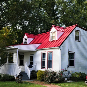 Brilliance Red Standing Seam Metal Roof on Home with White Siding
