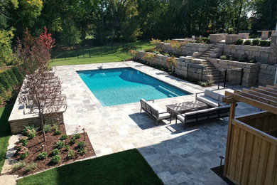 Pool landscaping - large coastal backyard stone and custom-shaped natural pool landscaping idea in Minneapolis