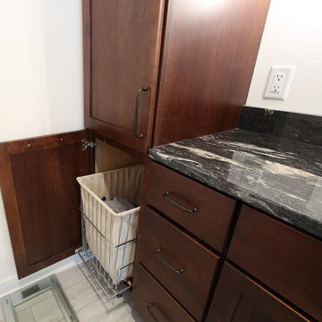 Pullout Hamper in Master Bathroom Vanity with Dark Stained Cabinets and Black Gr