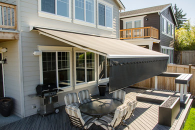 Photo of a mid-sized traditional backyard patio in Seattle with decking and an awning.