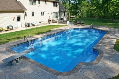 Photo of a mid-sized backyard rectangular pool in Boston with concrete slab.