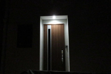 Mittelgroße Moderne Haustür mit weißer Wandfarbe, hellem Holzboden, Einzeltür, dunkler Holzhaustür und braunem Boden in Sonstige