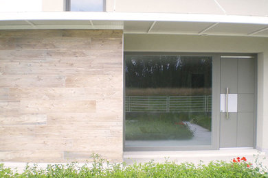 Photo of a large contemporary front door in Other with a gray front door.