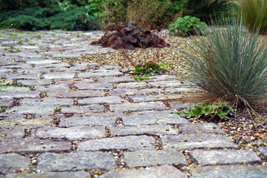 This is an example of a small mediterranean drought-tolerant and full sun backyard stone landscaping in London.