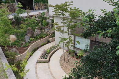 Diseño de jardín moderno de tamaño medio en primavera en patio con parterre de flores, exposición parcial al sol, adoquines de hormigón y con madera