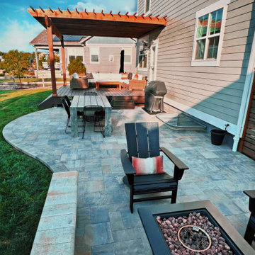 Combination backyard project featuring deck, pergola, and patio pavers
