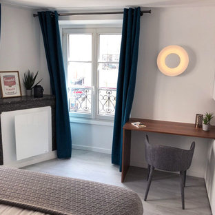 Inspiration for a medium sized modern study in Paris with white walls, lino flooring, a corner fireplace, a stone fireplace surround, a built-in desk and grey floors.