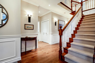Hallway - mid-sized traditional medium tone wood floor hallway idea in Toronto with gray walls