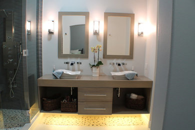 Alcove shower - large contemporary master brown tile and pebble tile pebble tile floor alcove shower idea in Los Angeles with a vessel sink, flat-panel cabinets, medium tone wood cabinets and white walls