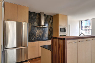Example of a mid-sized trendy galley medium tone wood floor eat-in kitchen design in Dallas with an undermount sink, flat-panel cabinets, light wood cabinets, black backsplash, stone slab backsplash, stainless steel appliances and no island