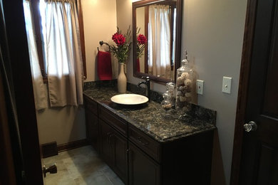 Bathroom - mid-sized traditional 3/4 multicolored tile and porcelain tile porcelain tile bathroom idea in Other with flat-panel cabinets, medium tone wood cabinets, a two-piece toilet, beige walls, a vessel sink and quartz countertops