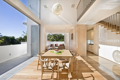 Inspiration for a large contemporary open plan dining in Sydney with white walls and light hardwood floors.