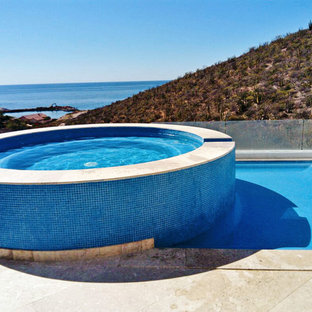 Exempel på en liten modern takterass, rund ovanmarkspool, med spabad och kakelplattor