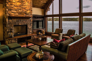 Inspiration for a timeless medium tone wood floor and brown floor living room remodel in Minneapolis with a standard fireplace and a stone fireplace
