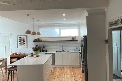 This is an example of a mid-sized modern l-shaped open plan kitchen in Melbourne.