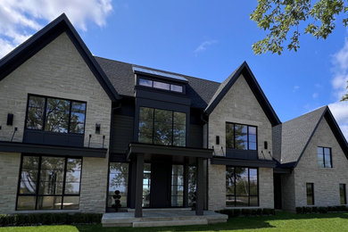 Example of a huge two-story stone exterior home design in Toronto with a mixed material roof and a black roof
