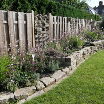 Insektenfreundlicher Garten mit Natursteinmauern und tiefergelegtem Sitzplatz