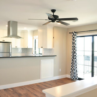 Diseño de salón abierto, mediterráneo, pequeño, sin chimenea, con paredes beige, suelo vinílico, televisor independiente y suelo marrón