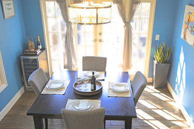 Diseño de comedor clásico renovado pequeño cerrado con paredes azules, suelo de madera oscura y suelo marrón