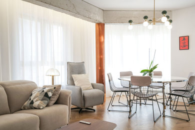 Modelo de salón abierto y beige y blanco nórdico con paredes blancas, suelo laminado y cortinas