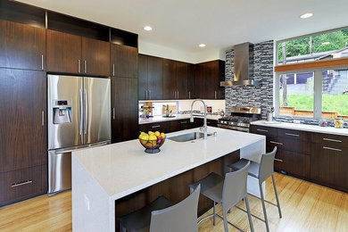 Inspiration for a large modern l-shaped eat-in kitchen in Seattle with flat-panel cabinets, dark wood cabinets, quartz benchtops, with island, an undermount sink, multi-coloured splashback, mosaic tile splashback, stainless steel appliances and light hardwood floors.