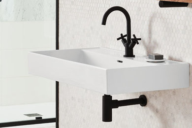 Modelo de cuarto de baño urbano con baldosas y/o azulejos blancos, lavabo suspendido y suelo gris