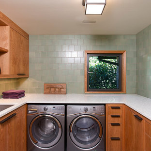 Inspiration for a medium sized contemporary u-shaped separated utility room in Portland with a built-in sink, flat-panel cabinets, medium wood cabinets, recycled glass countertops, green walls and a side by side washer and dryer.