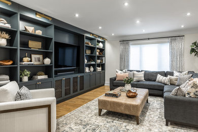 Mid-sized transitional open concept light wood floor and brown floor family room photo in Toronto with a wall-mounted tv