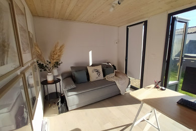 Kleines Skandinavisches Arbeitszimmer mit Arbeitsplatz, weißer Wandfarbe, hellem Holzboden und freistehendem Schreibtisch in Nantes