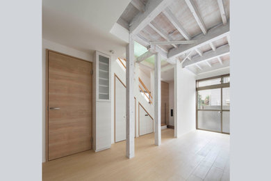 Modelo de salón abierto y blanco rústico pequeño con paredes blancas, suelo de madera clara, suelo beige, vigas vistas y papel pintado