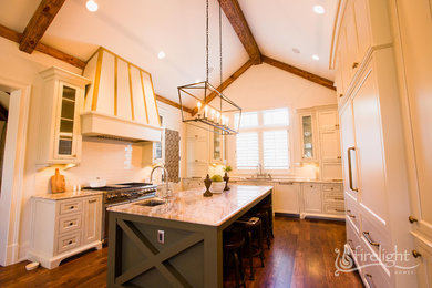 Enclosed kitchen - large transitional u-shaped medium tone wood floor and brown floor enclosed kitchen idea in Atlanta with an undermount sink, beaded inset cabinets, white cabinets, granite countertops, white backsplash, subway tile backsplash, paneled appliances and an island