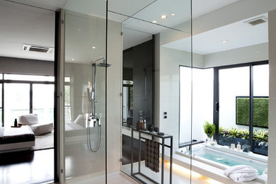 Example of a large trendy master concrete floor drop-in bathtub design in Other with an undermount sink, a one-piece toilet and white walls
