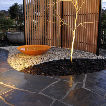 Curved crazy paving path with bespoke threaded timber batten privacy screen