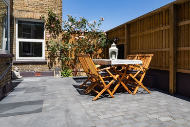 Photo of a small contemporary courtyard private full sun garden for summer in London with natural stone paving.