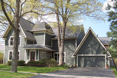 Photo of a large two-storey green exterior in Detroit with wood siding.