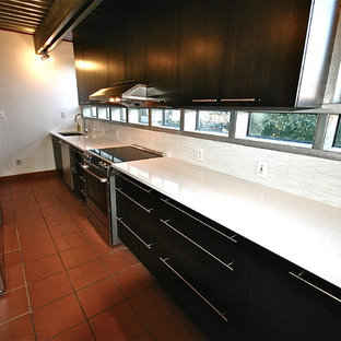 Mid-sized modern kitchen pantry ideas - Mid-sized minimalist galley ceramic floor kitchen pantry photo in New Orleans with an undermount sink, flat-panel cabinets, dark wood cabinets, quartz countertops, white backsplash, matchstick tile backsplash, stainless steel appliances and no island