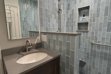Example of a small transitional 3/4 blue tile and ceramic tile pebble tile floor, multicolored floor and single-sink bathroom design in Other with shaker cabinets, dark wood cabinets, a bidet, white walls, an undermount sink, quartz countertops, a hinged shower door, gray countertops and a freestanding vanity
