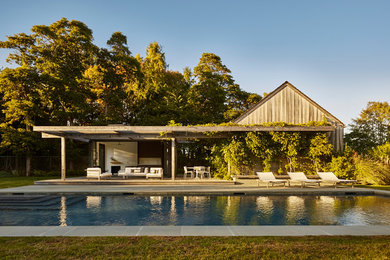 Beach style backyard stone and rectangular pool photo in New York