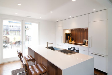 Inspiration for a small contemporary single-wall eat-in kitchen in San Francisco with an undermount sink, flat-panel cabinets, white cabinets, quartz benchtops, brown splashback, panelled appliances, medium hardwood floors and with island.