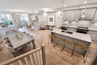 Mid-sized transitional l-shaped light wood floor and brown floor kitchen photo in Ottawa with an undermount sink, recessed-panel cabinets, gray cabinets, quartz countertops, gray backsplash, mosaic tile backsplash, stainless steel appliances, an island and gray countertops