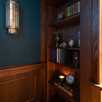 Aged Brass Wall Sconce Against Teal Grasscloth and Walnut Paneling