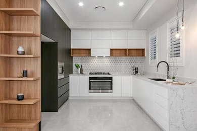 This is an example of a mid-sized modern u-shaped eat-in kitchen in Sydney with an undermount sink, flat-panel cabinets, white cabinets, quartz benchtops, white splashback, mosaic tile splashback, stainless steel appliances, porcelain floors, no island, grey floor, white benchtop and coffered.