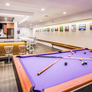 Design ideas for a large modern fully buried basement in New York with beige walls, no fireplace, dark hardwood flooring and brown floors.