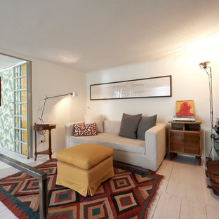 Kleines Mediterranes Wohnzimmer im Loft-Stil, ohne Kamin mit weißer Wandfarbe, gebeiztem Holzboden, Wand-TV und weißem Boden in Mailand