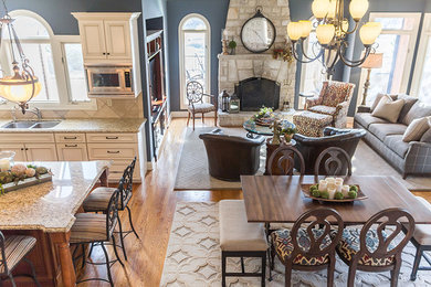 Mid-sized transitional medium tone wood floor kitchen/dining room combo photo in St Louis with blue walls, a standard fireplace and a stone fireplace