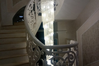 Diseño de escalera curva clásica con escalones de mármol, contrahuellas de mármol y barandilla de varios materiales